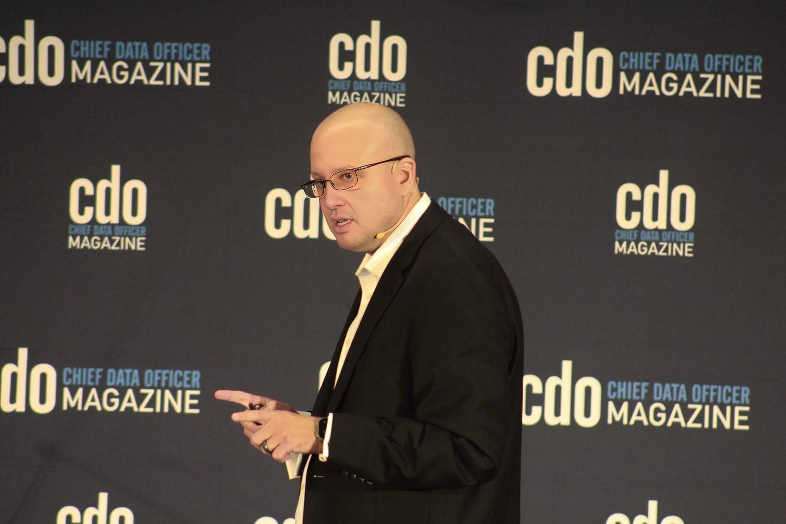 Thomas Mazzaferro speaking in front of a Chief Data Officer Magazine backdrop.