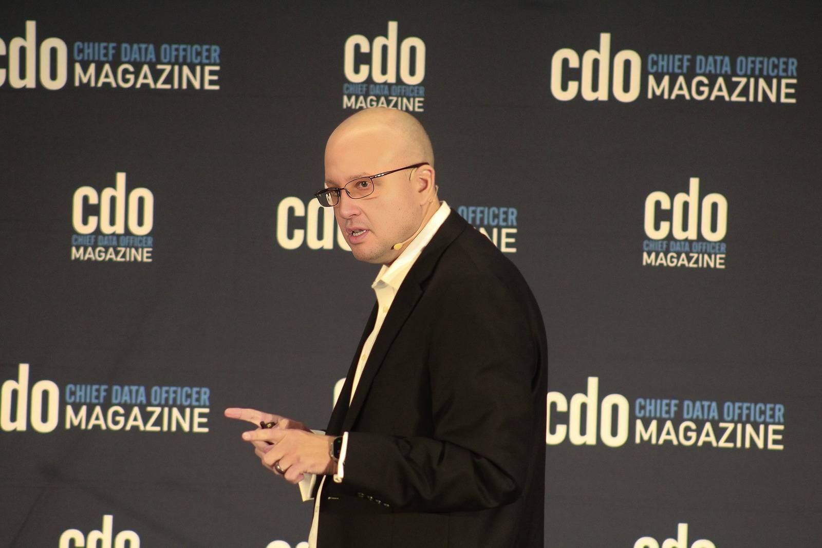 Thomas Mazzaferro speaking in front of a Chief Data Officer Magazine backdrop, gesturing as he makes a point.
