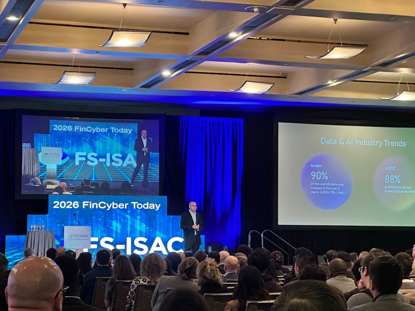 A large seated conference audience facing the main stage at the FS-ISAC FinCyber Today 2026 event, with Thomas Mazzaferro presenting.