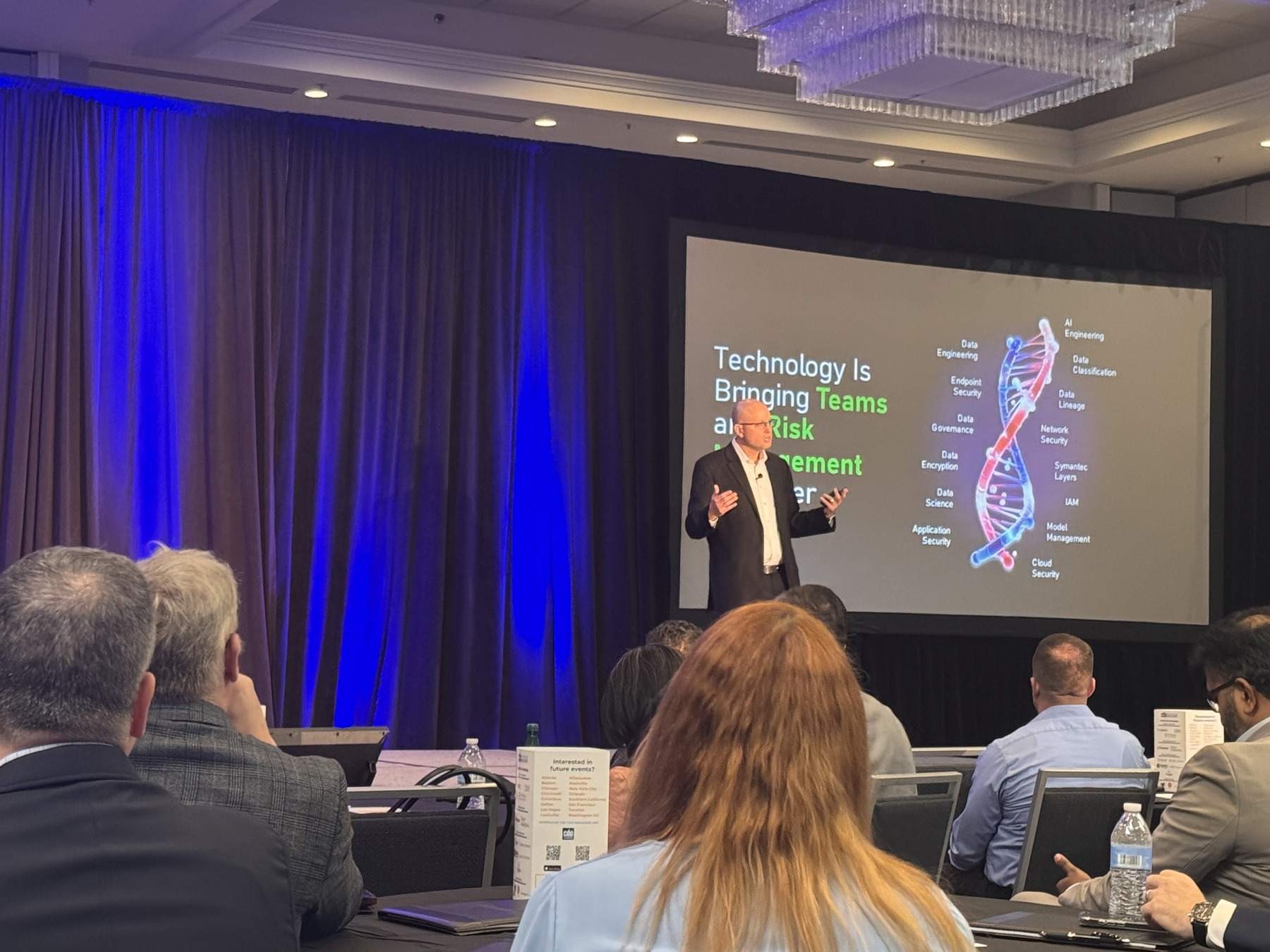Thomas Mazzaferro presenting, with a slide behind him on bringing teams and risk management together.